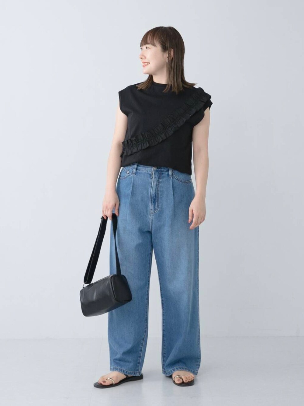 ブラック系のサンダル、ブルー系のデニムパンツ、ブラック系のTシャツ/カットソーを着用したレディースの夏コーディネートの1枚目の写真