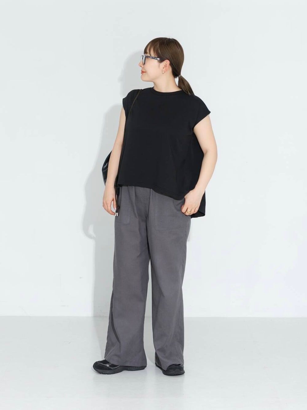 グレー系のその他パンツ、ブラック系のTシャツ/カットソー、ブラック系のバックパック/リュックを着用したレディースの春コーディネートの1枚目の写真
