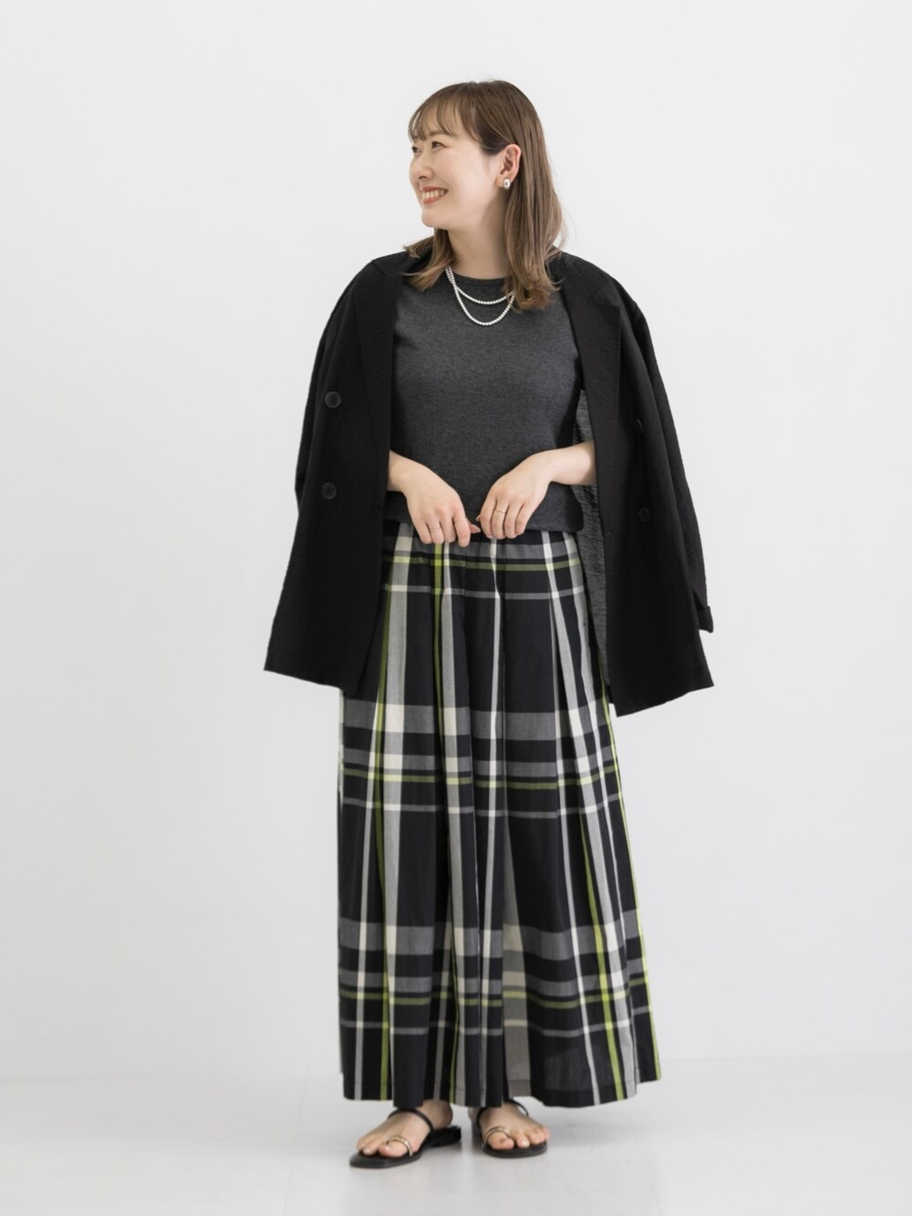 ブラック系のスカート、グレー系のTシャツ/カットソー、ブラック系のテーラードジャケットを着用したレディースの春コーディネートの1枚目の写真