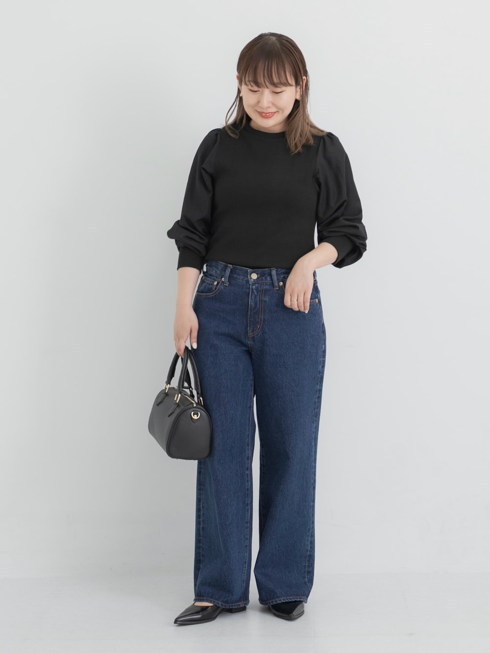 ブルー系のデニムパンツ、ブラック系のボストンバッグ、ブラック系のその他シューズを着用したレディースの秋コーディネートの1枚目の写真