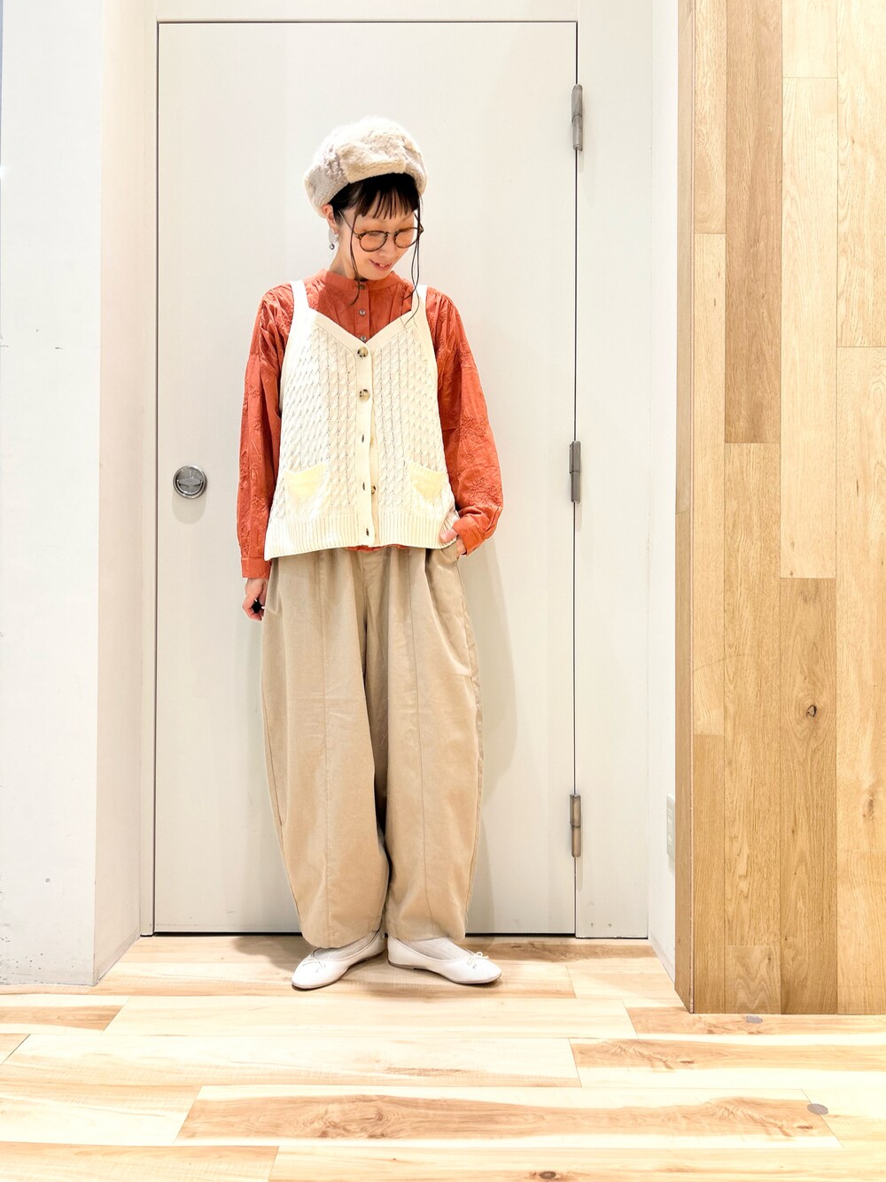 ホワイト系のベスト、オレンジ系のシャツ/ブラウス、ベージュ系のその他パンツを着用したレディースの秋コーディネートの1枚目の写真