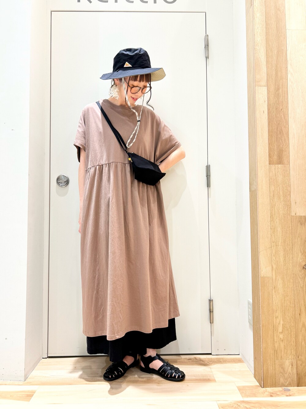 ブラック系のハンドバッグ、ブラウン系のワンピース、ブラック系のその他パンツを着用したレディースの春コーディネートの1枚目の写真