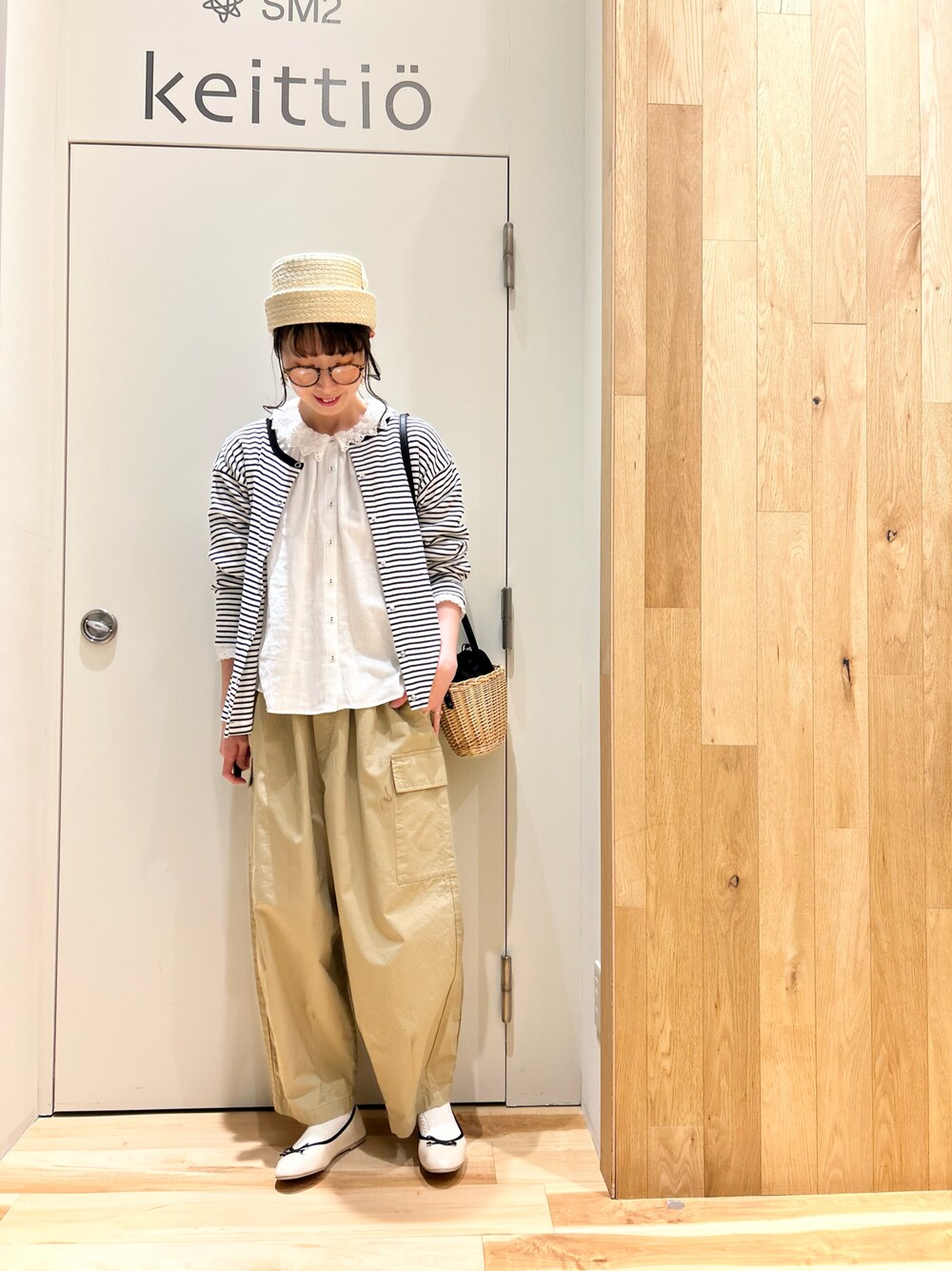 ホワイト系のシャツ/ブラウス、ブラック系のカーディガン/ボレロ、ブラック系のハンドバッグを着用したレディースの春コーディネートの1枚目の写真