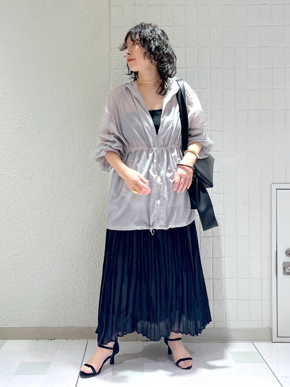 ブラック系のショルダーバッグ、グレー系のブルゾン、ブラック系のサンダルを着用したレディースの春コーディネートの1枚目の写真