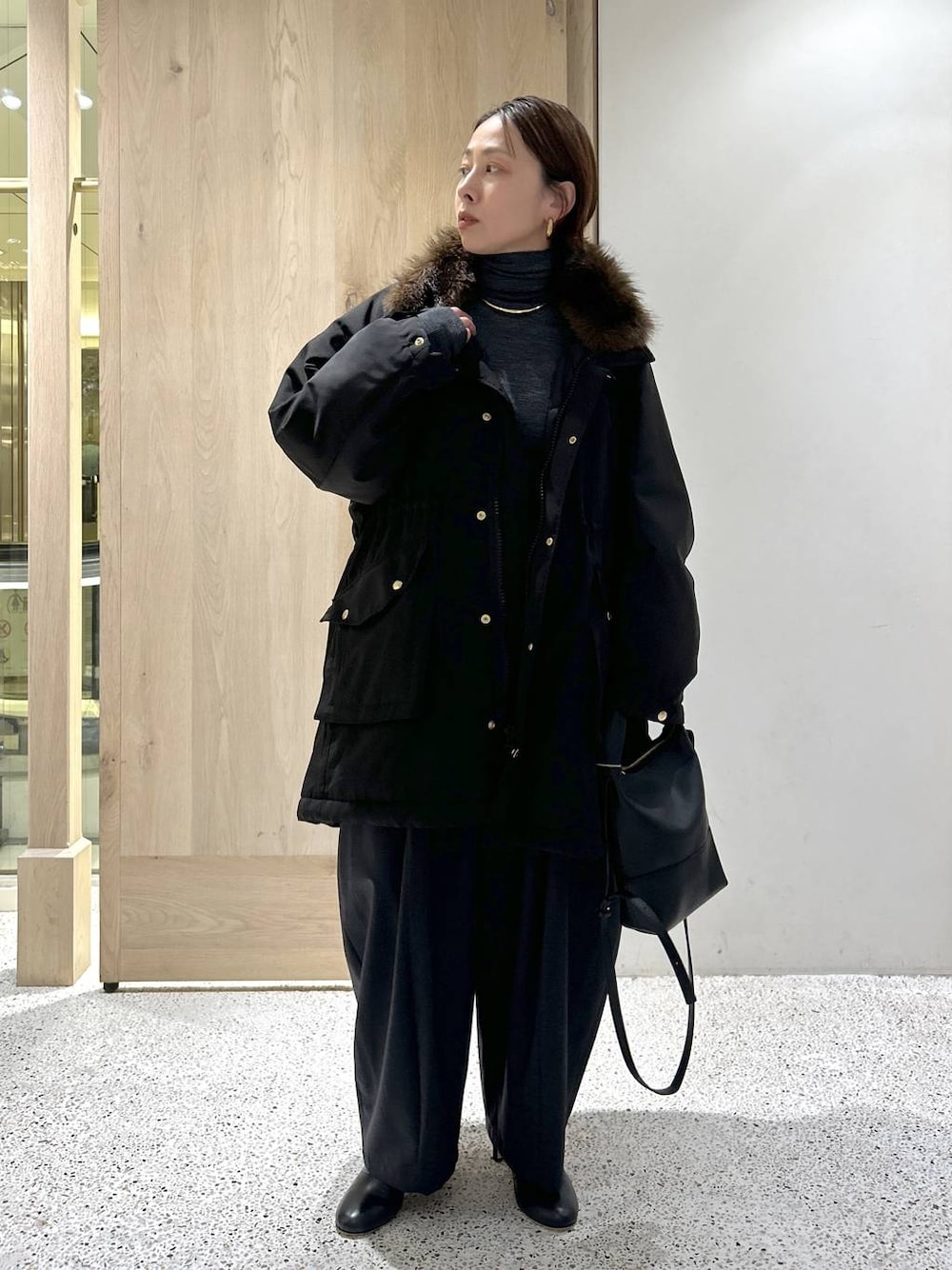 ブラック系のショルダーバッグ、ブラック系のモッズコート、グレー系のニット/セーターを着用したレディースの秋コーディネートの1枚目の写真