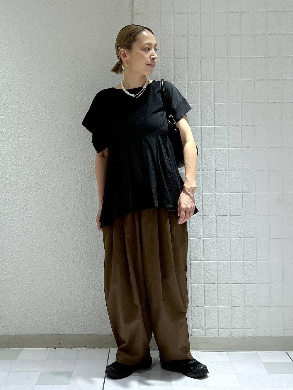 ブラック系のシャツ/ブラウス、ブラック系のショルダーバッグ、ブラウン系のその他パンツを着用したレディースの夏コーディネートの1枚目の写真