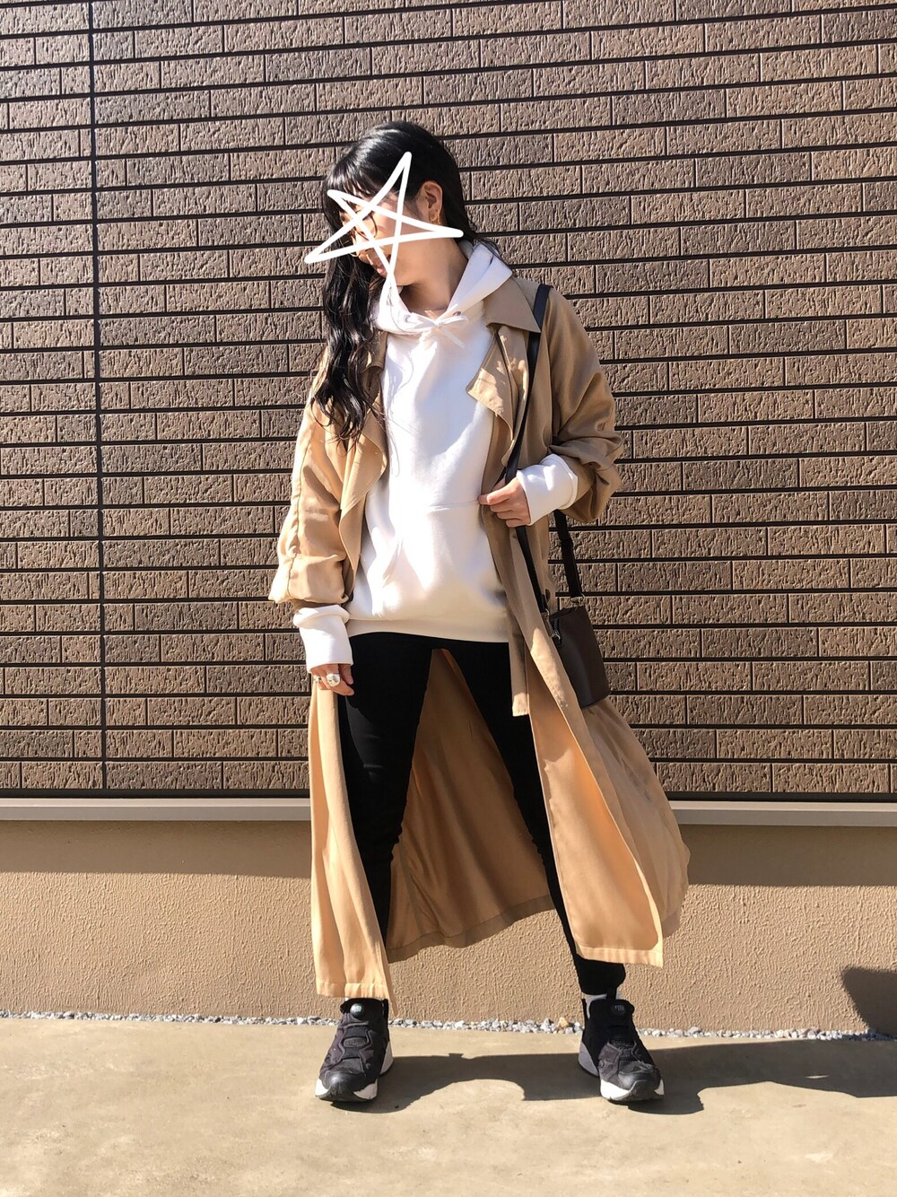 ホワイト系のパーカー、ベージュ系のトレンチコート、ブラウン系のショルダーバッグを着用したレディースの秋コーディネートの1枚目の写真
