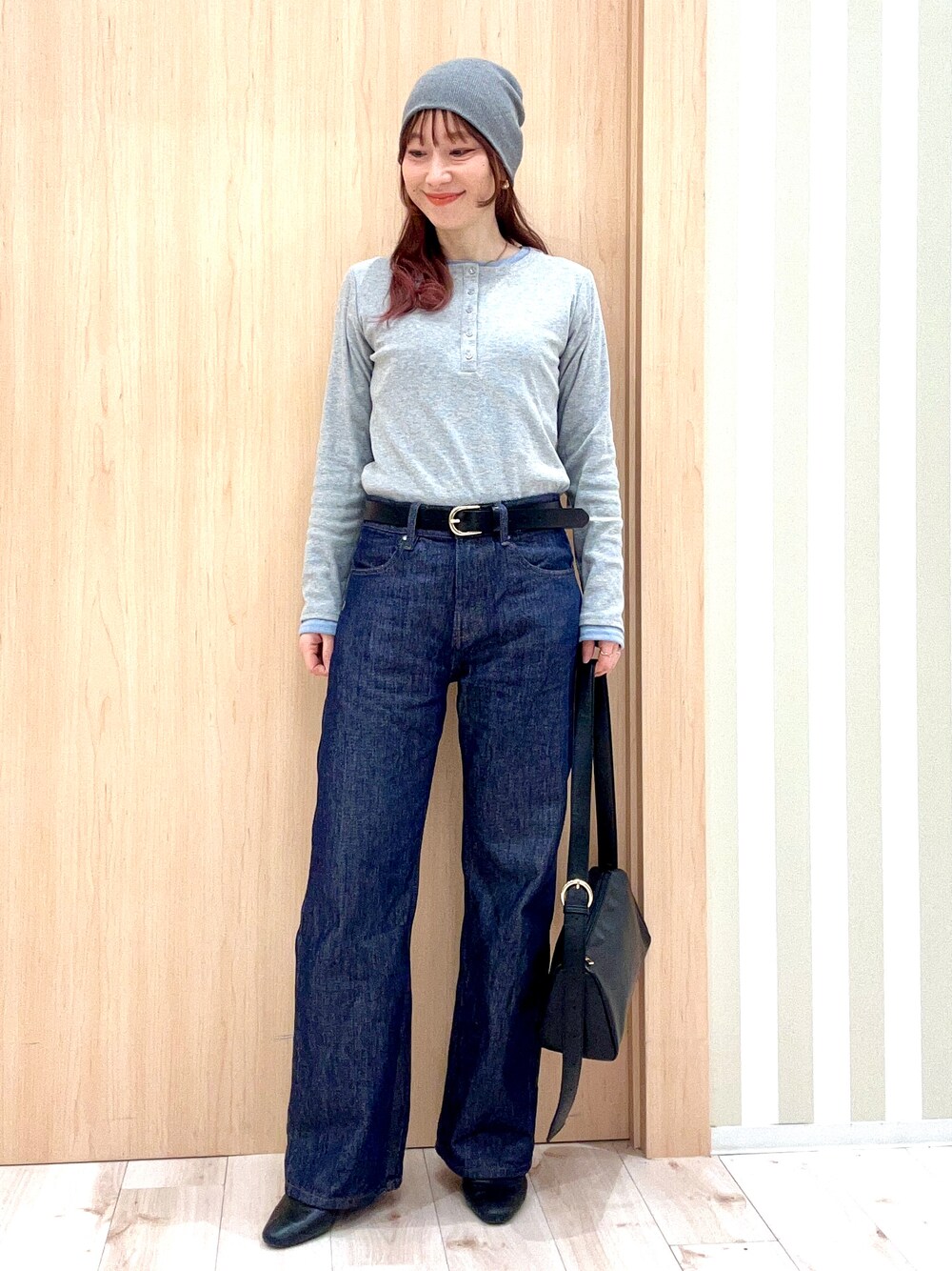 グレー系のTシャツ/カットソー、ブルー系のデニムパンツ、ブラック系のショルダーバッグを着用したレディースの春コーディネートの1枚目の写真