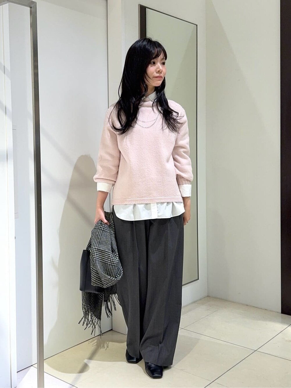 ピンク系のニット/セーター、ホワイト系のシャツ/ブラウス、グレー系のその他パンツを着用したレディースの冬コーディネートの1枚目の写真