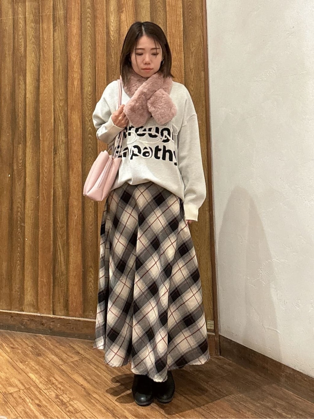ホワイト系のニット/セーター、ベージュ系のスカート、ピンク系のショルダーバッグを着用したレディースの冬コーディネートの1枚目の写真