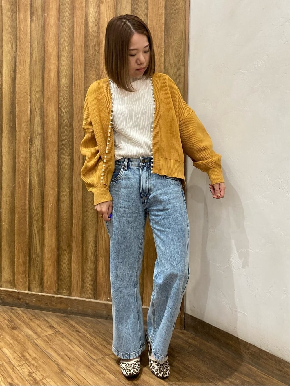 イエロー系のパンプスを着用したレディースの秋コーディネートの1枚目の写真