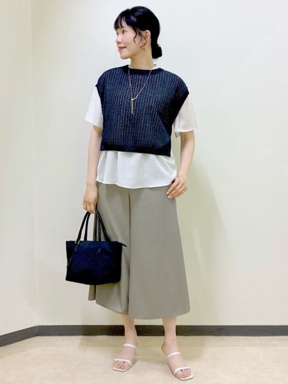 ベージュ系のシャツ/ブラウス、ブラック系のニット/セーター、グレー系のタンクトップを着用したレディースの夏コーディネートの1枚目の写真