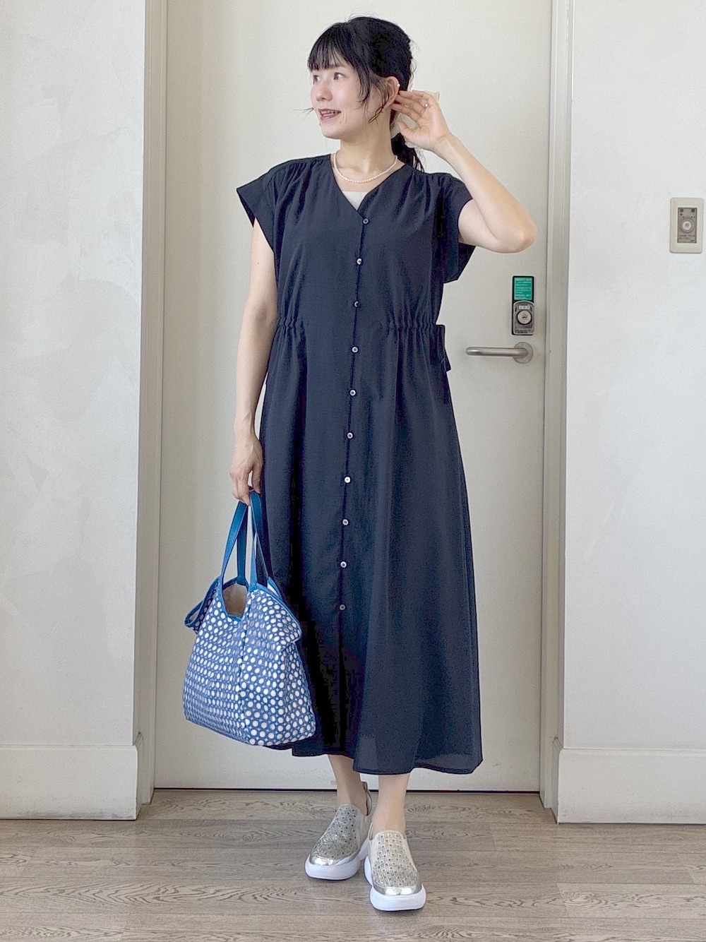 ブルー系のワンピース、ベージュ系のタンクトップ、ブルー系のブルゾンを着用したレディースの春コーディネートの1枚目の写真