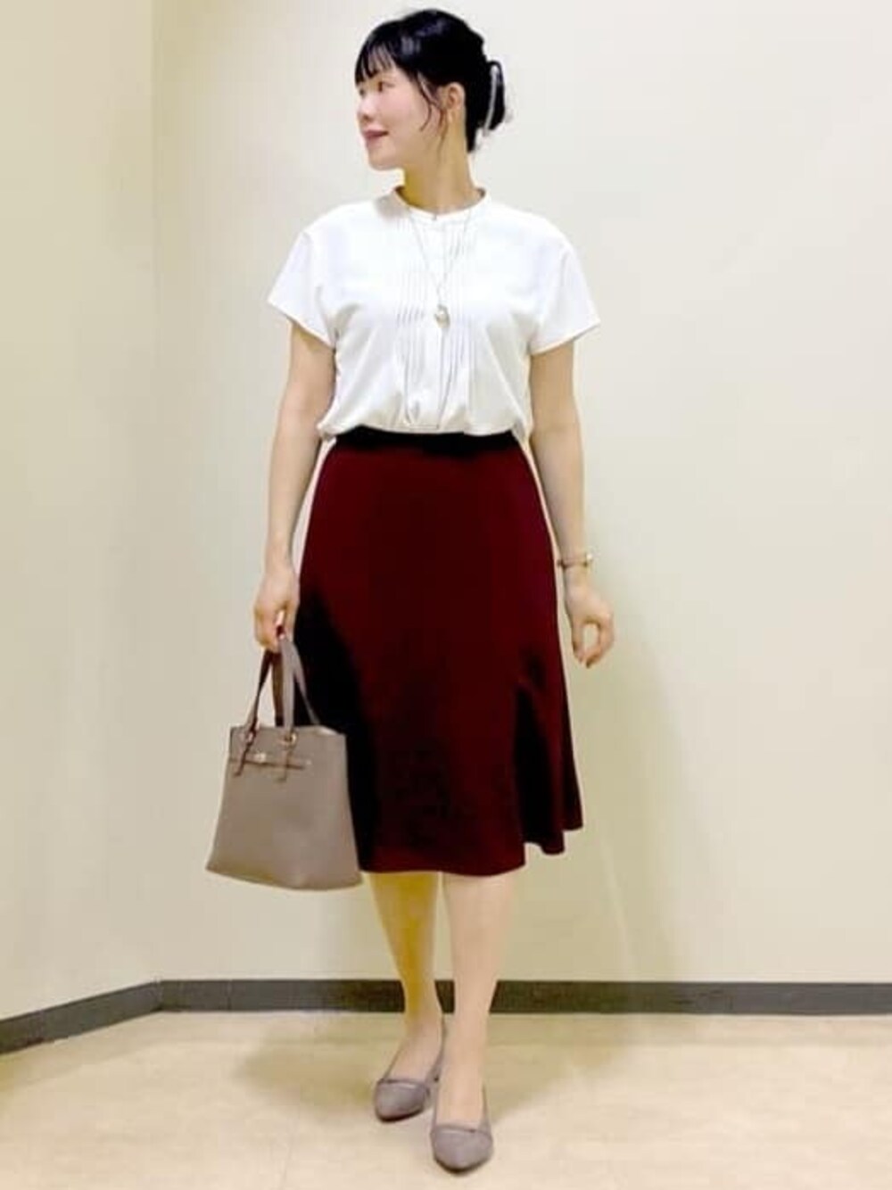 ホワイト系のシャツ/ブラウス、ベージュ系のカーディガン/ボレロ、レッド系のスカートを着用したレディースの秋コーディネートの1枚目の写真