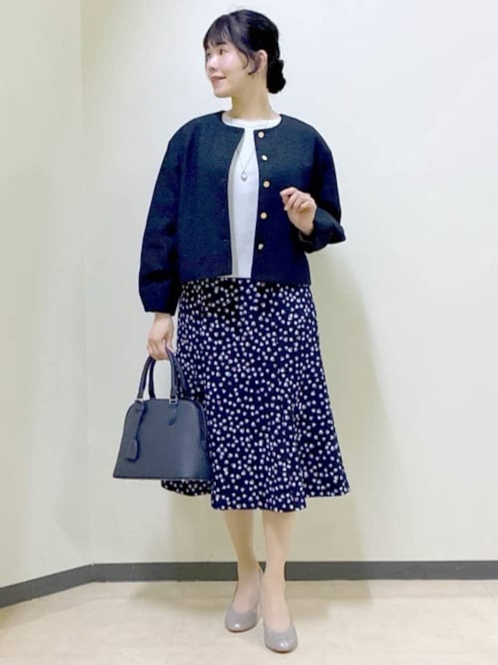 ブルー系のノーカラージャケット、グレー系のニット/セーター、ブルー系のスカートを着用したレディースの冬コーディネートの1枚目の写真