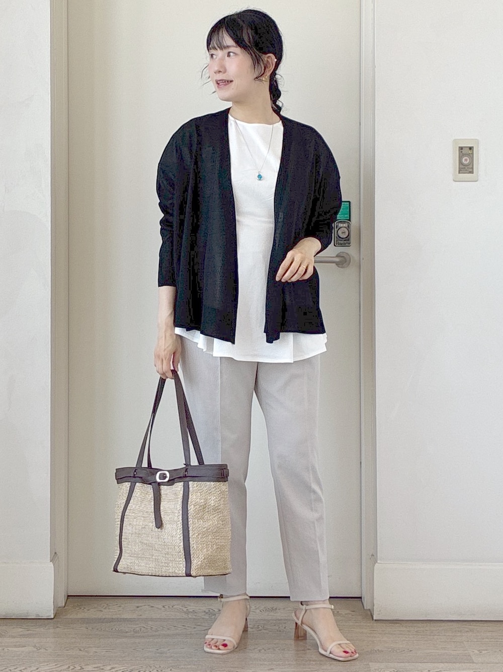 ブラック系のカーディガン/ボレロ、ホワイト系のTシャツ/カットソー、ベージュ系のタンクトップを着用したレディースの夏コーディネートの1枚目の写真