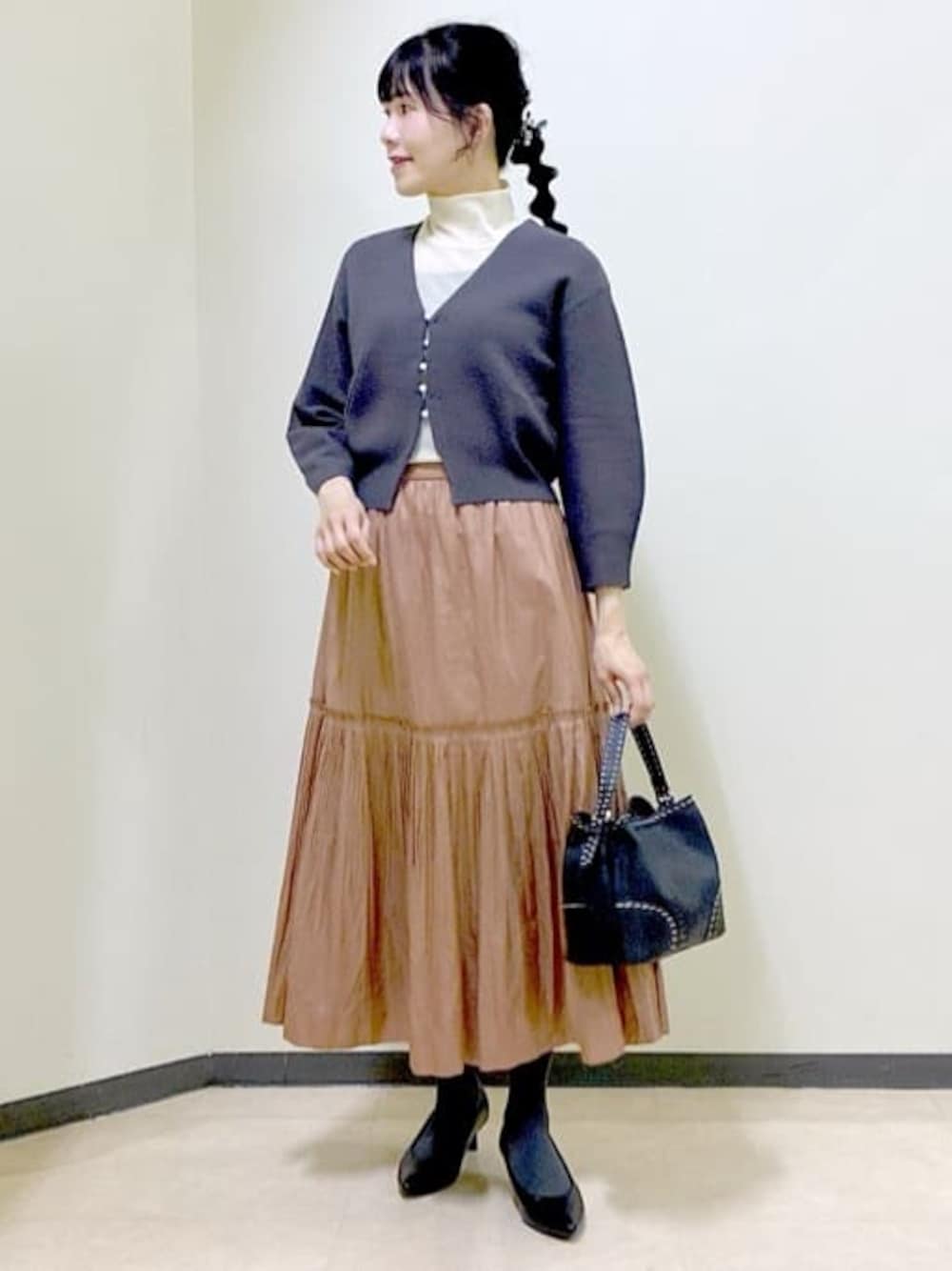 グレー系のカーディガン/ボレロ、ブラック系のタンクトップ、ホワイト系のTシャツ/カットソーを着用したレディースの冬コーディネートの1枚目の写真
