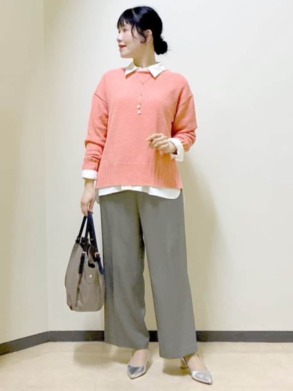 オレンジ系のニット/セーター、ホワイト系のシャツ/ブラウス、ベージュ系のその他パンツを着用したレディースの春コーディネートの1枚目の写真