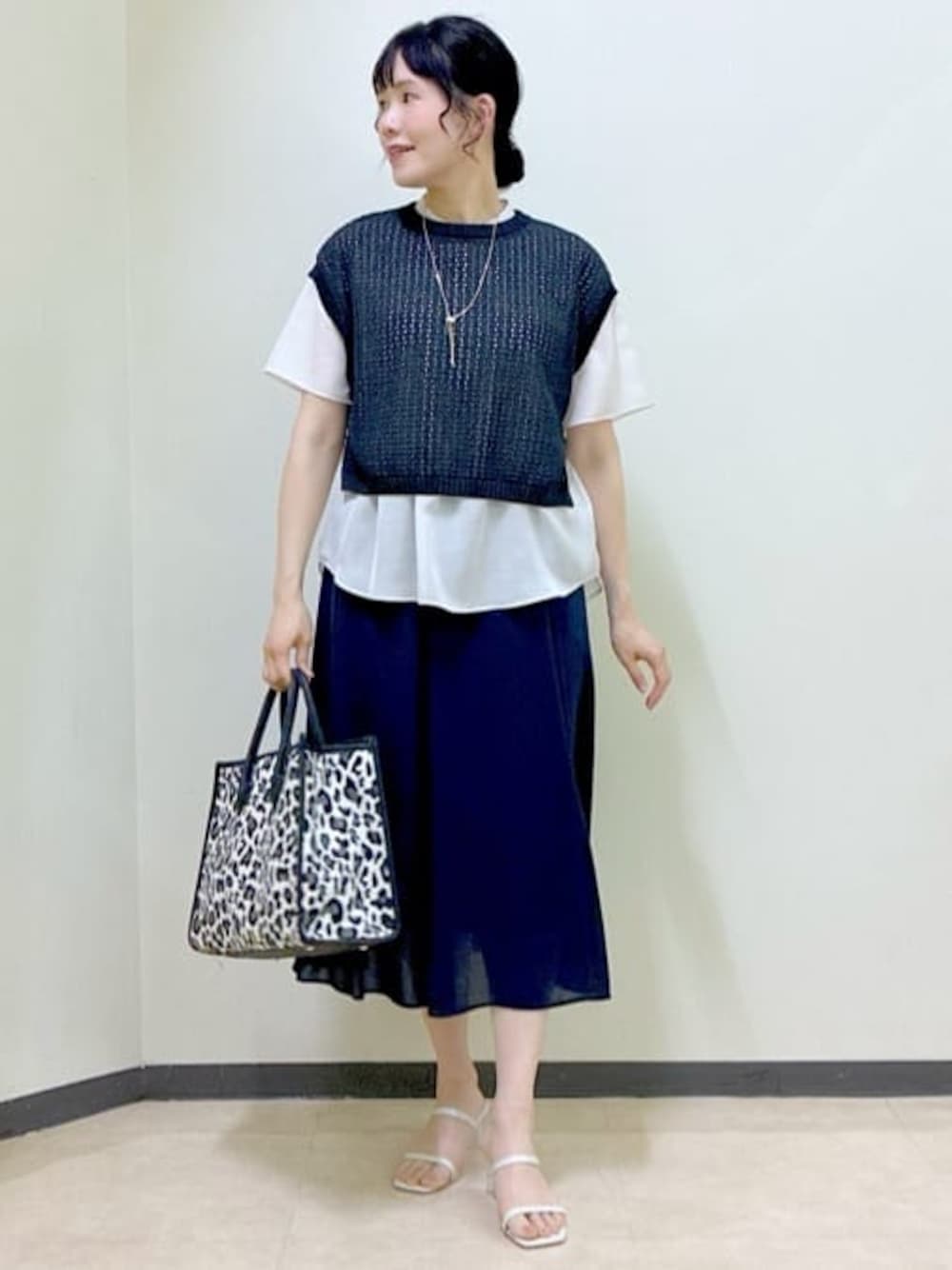 ベージュ系のシャツ/ブラウス、ブラック系のニット/セーター、ブルー系のスカートを着用したレディースの夏コーディネートの1枚目の写真