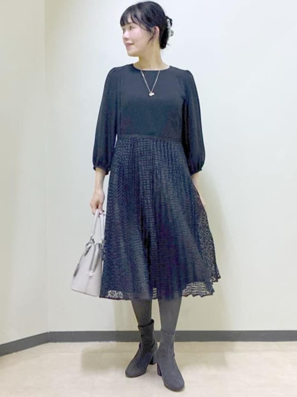 ブルー系のワンピース、グレー系のチェスターコート、ベージュ系のハンドバッグを着用したレディースの冬コーディネートの1枚目の写真