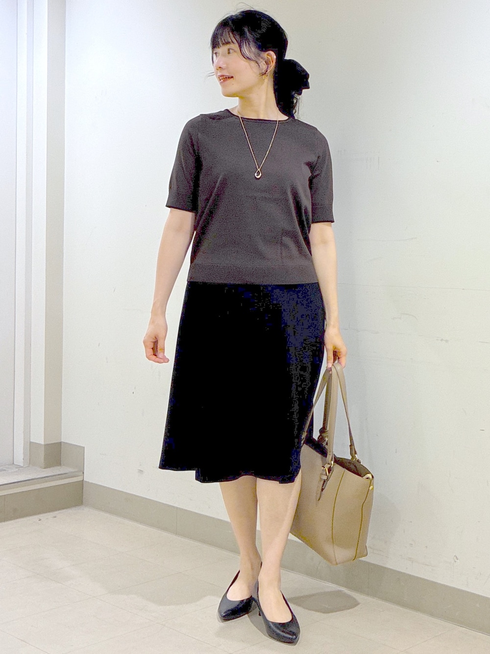 ブラウン系のニット/セーター、ブラウン系のカーディガン/ボレロ、ブラック系のスカートを着用したレディースの秋コーディネートの1枚目の写真