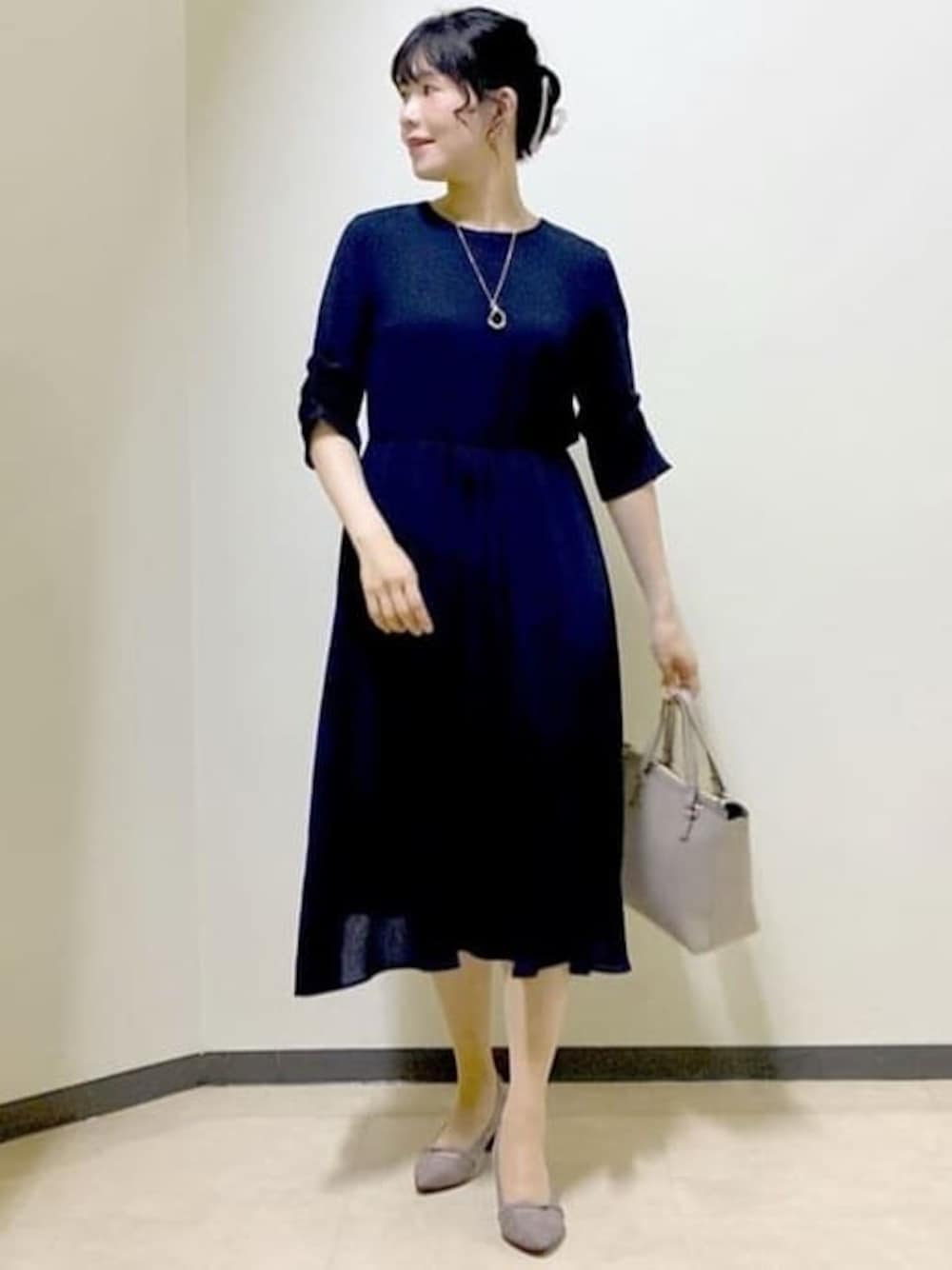 ブルー系のワンピース、ピンク系のカーディガン/ボレロ、ベージュ系のハンドバッグを着用したレディースの秋コーディネートの1枚目の写真