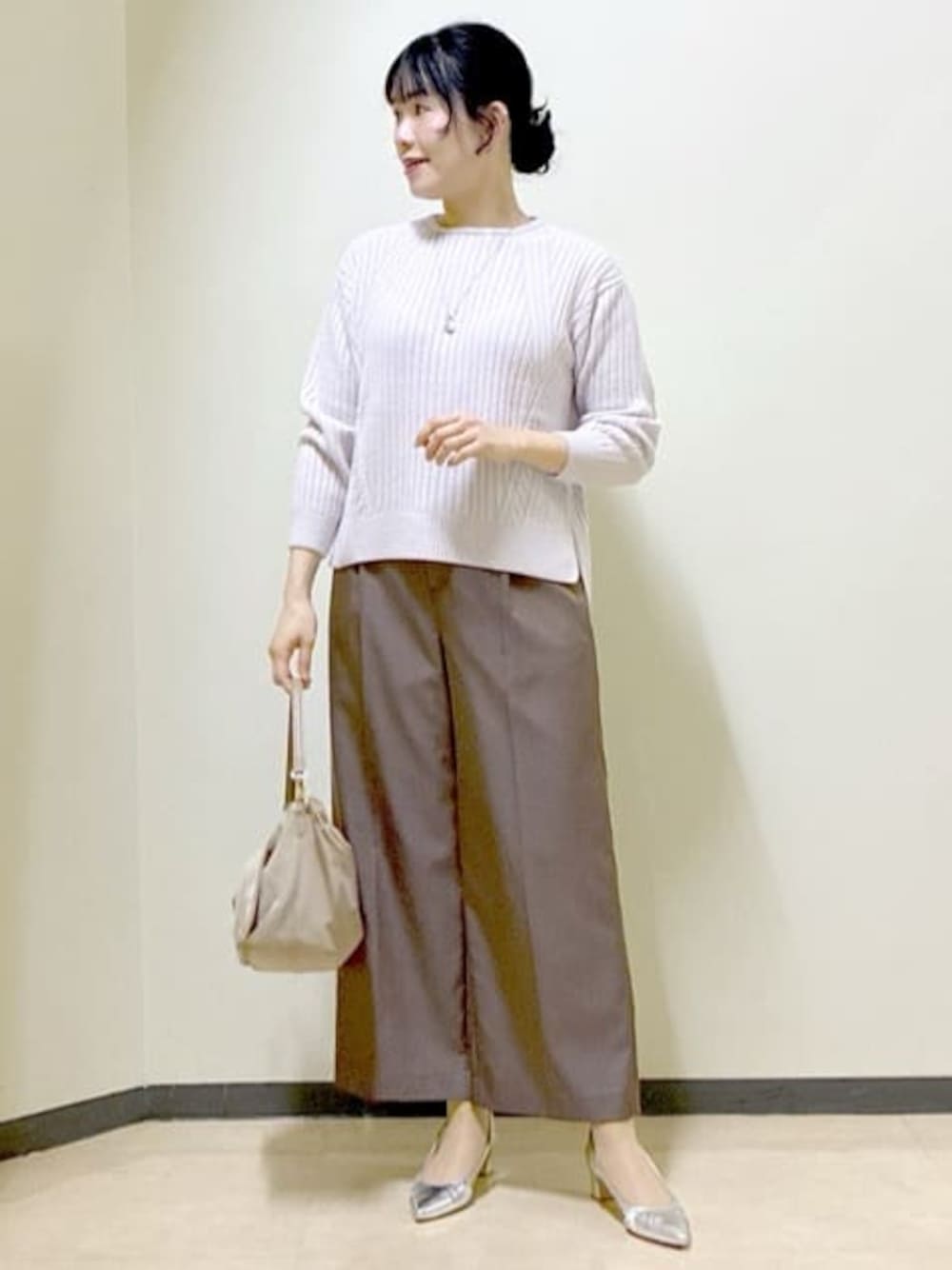 グレー系のニット/セーター、ブラウン系のその他パンツ、ベージュ系のショルダーバッグを着用したレディースの冬コーディネートの1枚目の写真