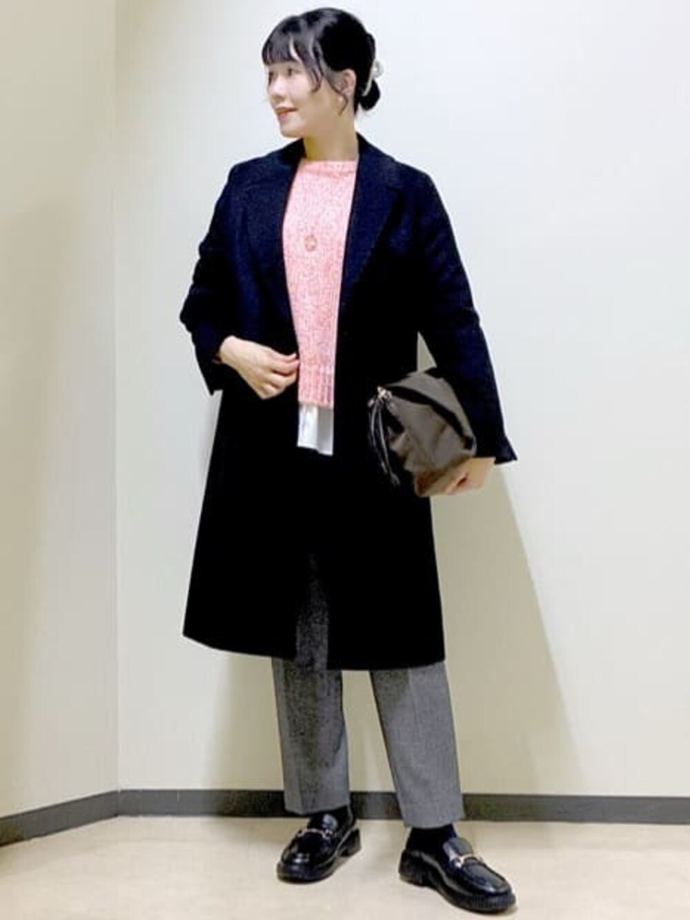 ブラック系のチェスターコート、レッド系のニット/セーター、ホワイト系のTシャツ/カットソーを着用したレディースの冬コーディネートの1枚目の写真