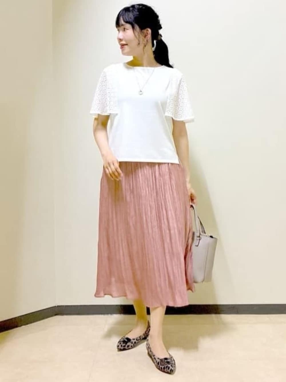 ホワイト系のTシャツ/カットソー、ベージュ系のカーディガン/ボレロ、ピンク系のスカートを着用したレディースの秋コーディネートの1枚目の写真