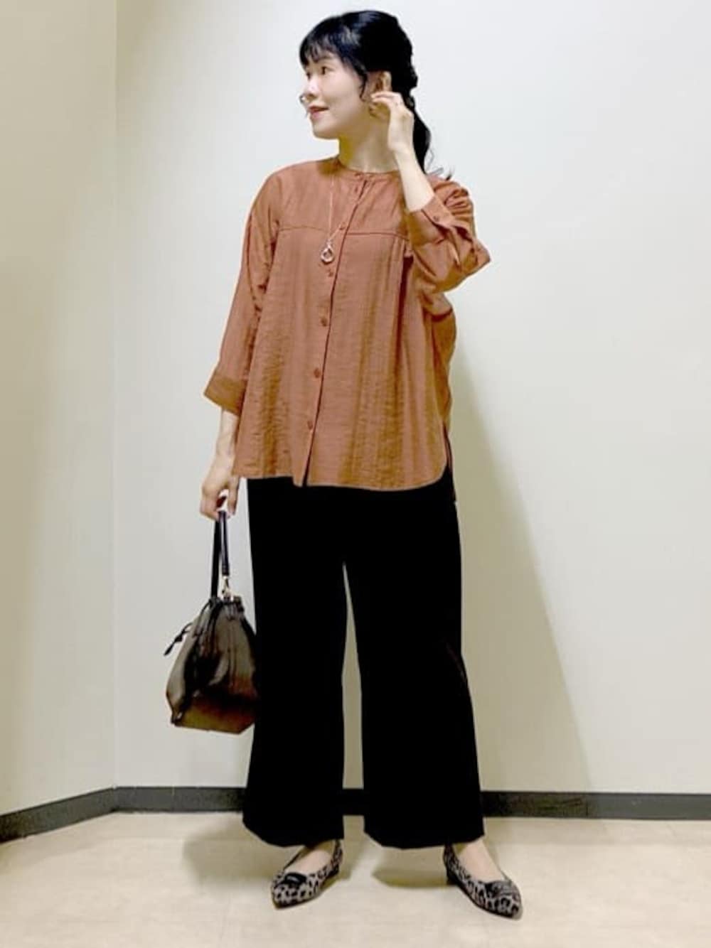 オレンジ系のシャツ/ブラウス、ブラック系のタンクトップ、ブラウン系のその他パンツを着用したレディースの秋コーディネートの1枚目の写真