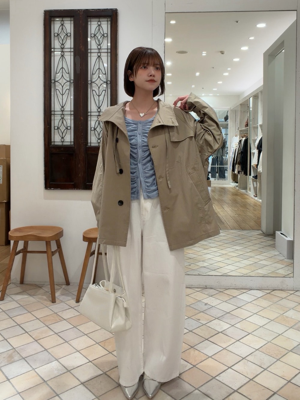 ブルー系のカーディガン/ボレロ、ベージュ系のトレンチコート、ホワイト系のデニムパンツを着用したレディースの春コーディネートの1枚目の写真