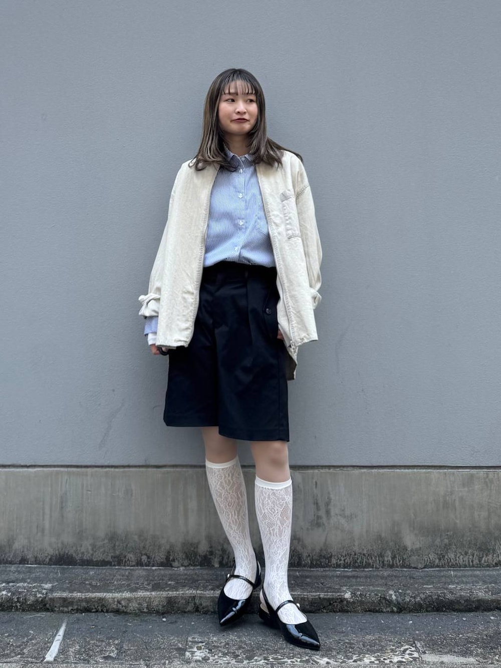 ブラック系のパンプス、ブラック系のスラックス、ブルー系のシャツ/ブラウスを着用したレディースの春コーディネートの1枚目の写真