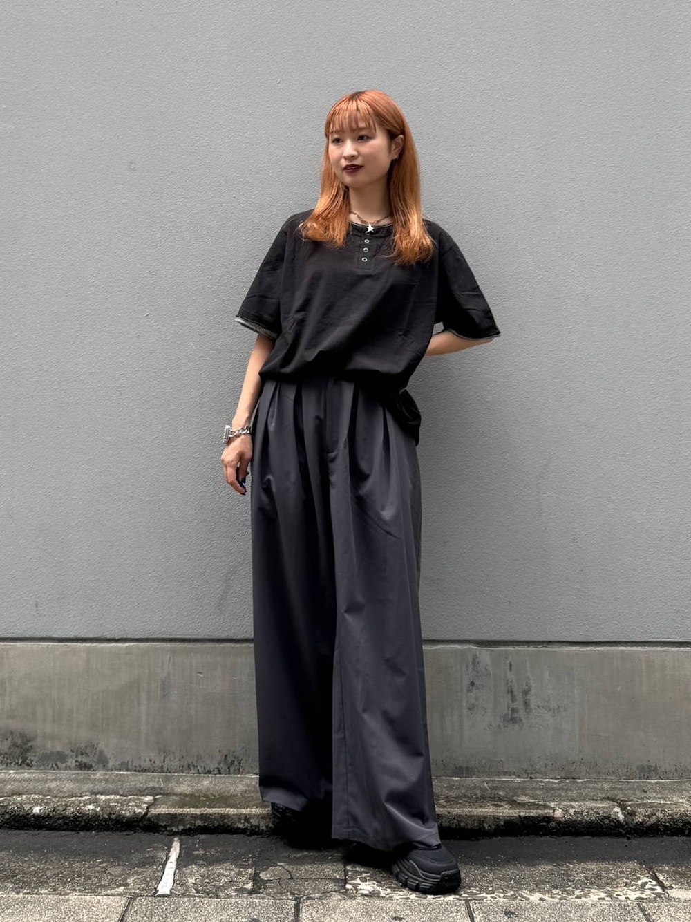 ブラック系のTシャツ/カットソー、グレー系のスラックス、ブラック系のサンダルを着用したレディースの夏コーディネートの1枚目の写真