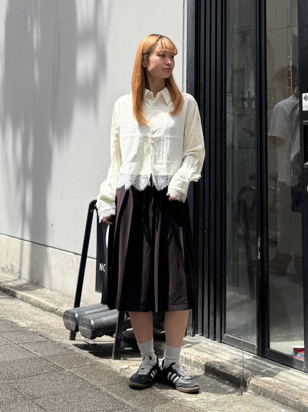 ブラウン系のスカート、ホワイト系のシャツ/ブラウスを着用したレディースの夏コーディネートの1枚目の写真