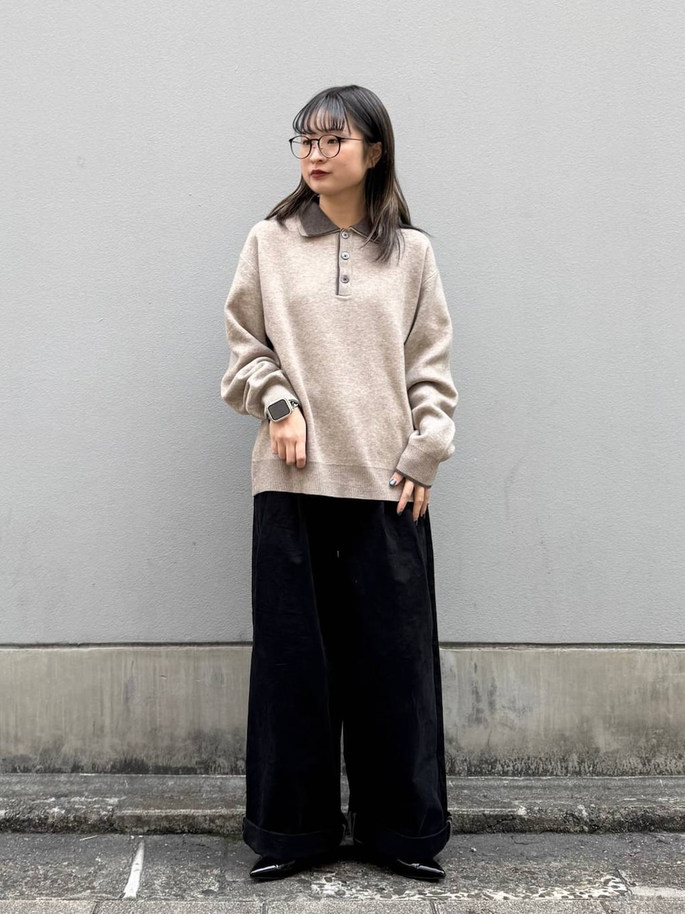 ブラック系のパンプス、ブラック系のチノパンツ、ベージュ系のニット/セーターを着用したレディースの春コーディネートの1枚目の写真