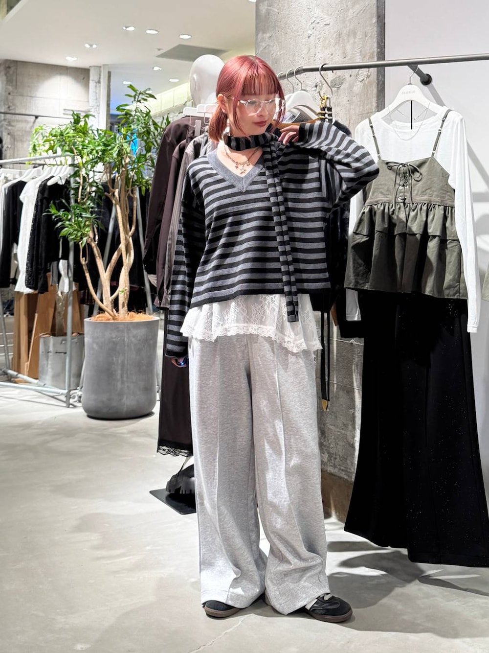 ホワイト系のTシャツ/カットソー、ブラック系のニット/セーター、グレー系のスウェットパンツを着用したレディースの秋コーディネートの1枚目の写真