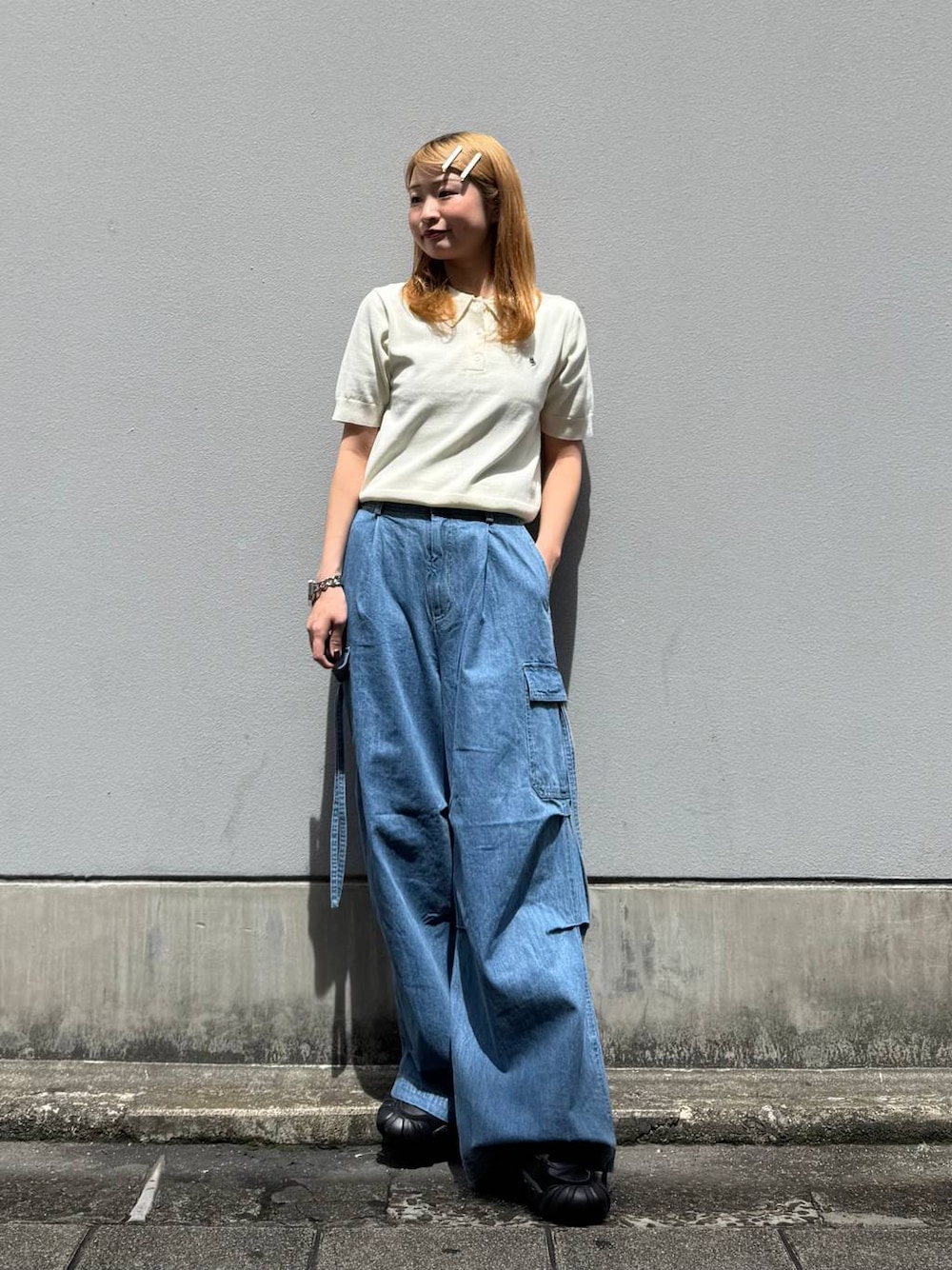 ブルー系のデニムパンツ、ホワイト系のポロシャツを着用したレディースの春コーディネートの1枚目の写真