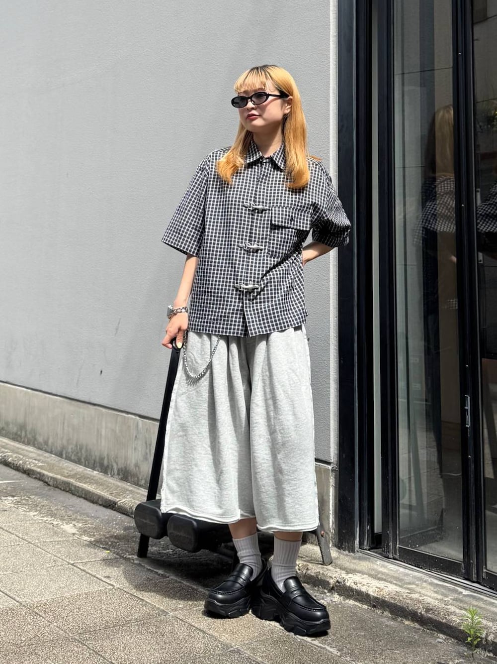 グレー系のスウェットパンツ、ブルー系のシャツ/ブラウス、ブラック系のサングラスを着用したレディースの夏コーディネートの1枚目の写真