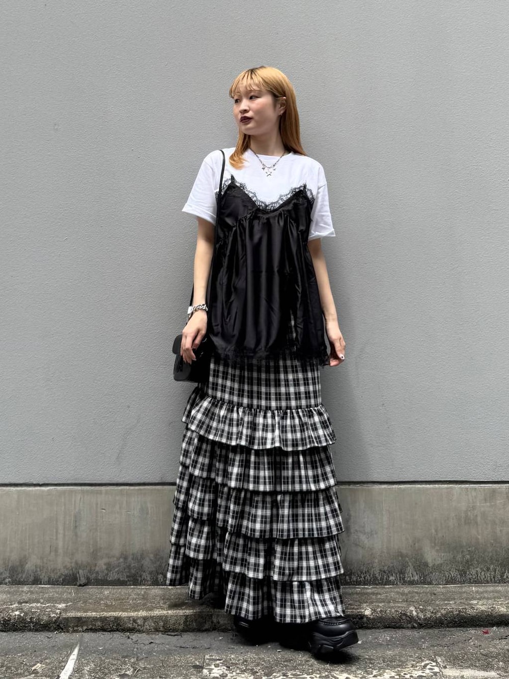 ブラック系のローファー、ブラック系のスカート、ブラック系のショルダーバッグを着用したレディースの夏コーディネートの1枚目の写真