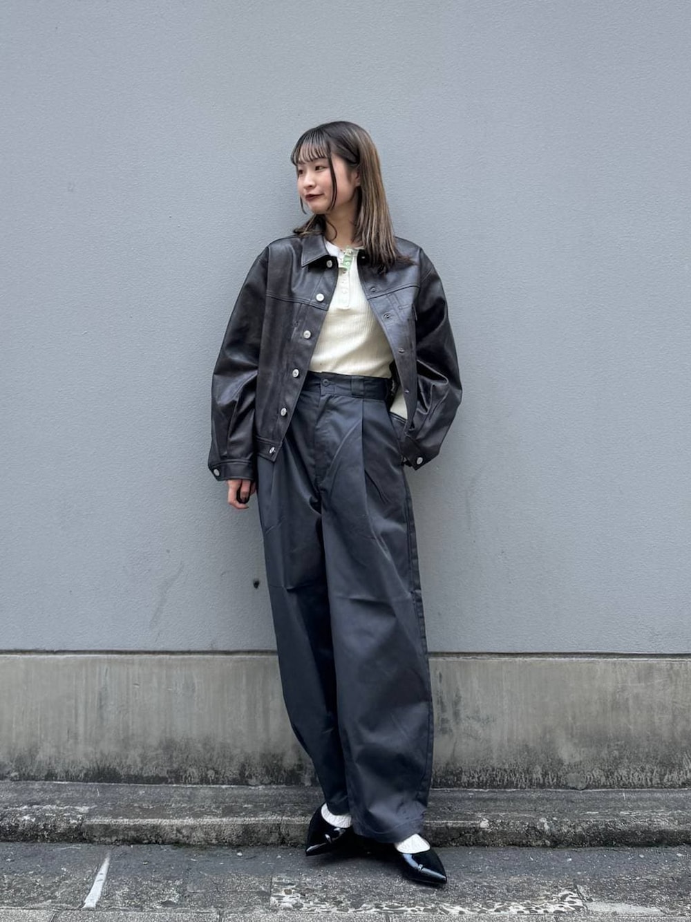 グレー系のチノパンツ、レッド系のパンプス、ブラウン系のブルゾンを着用したレディースの春コーディネートの1枚目の写真