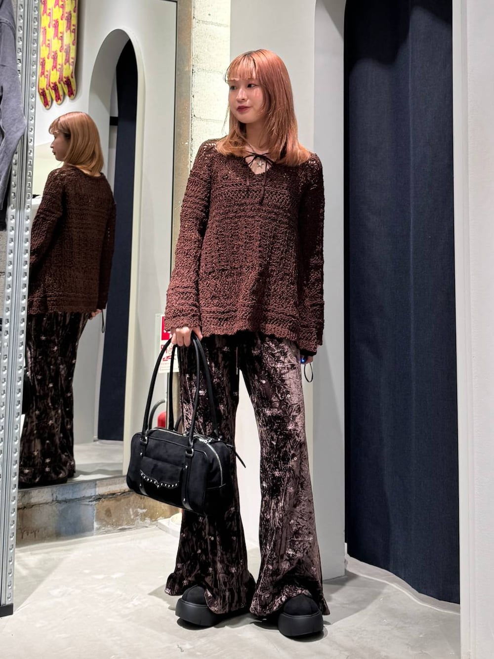 ブラウン系のその他パンツ、ブラック系のブーツ、ブラック系のショルダーバッグを着用したレディースの秋コーディネートの1枚目の写真