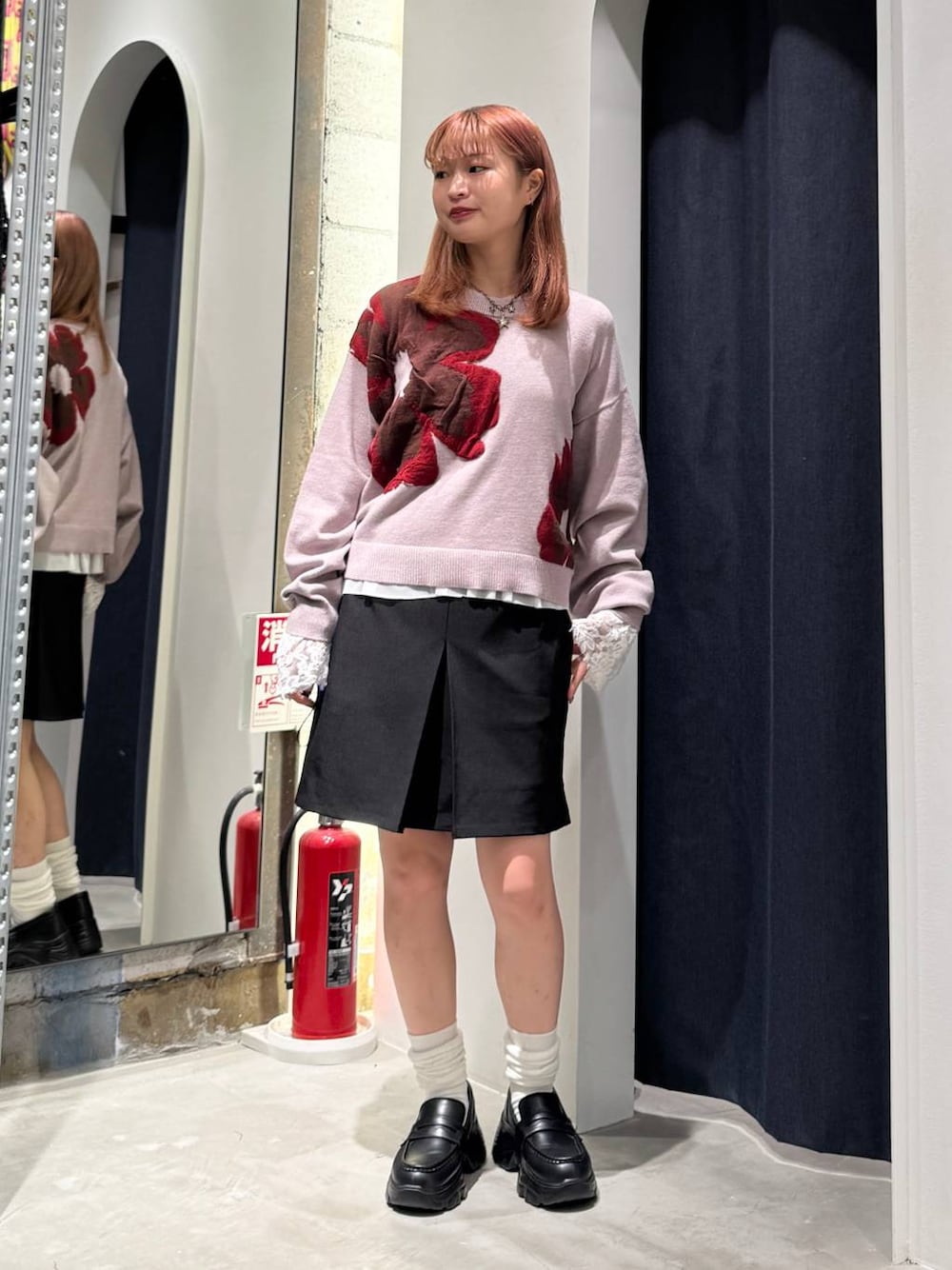 ホワイト系のTシャツ/カットソー、ピンク系のニット/セーター、ブラック系のスカートを着用したレディースの秋コーディネートの1枚目の写真