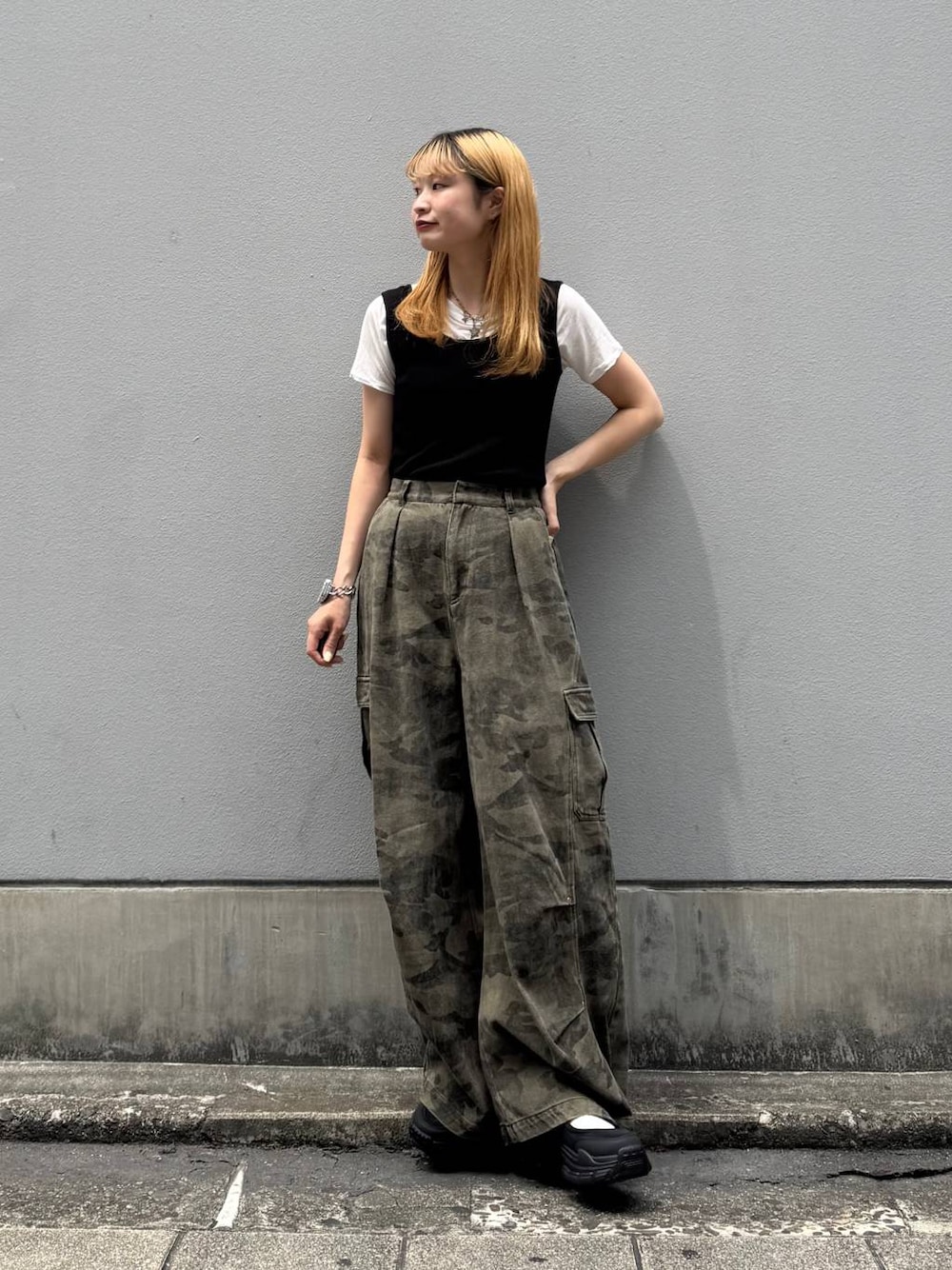 グリーン系のカーゴパンツ、ブラック系のタンクトップ、ブラック系のサンダルを着用したレディースの夏コーディネートの1枚目の写真