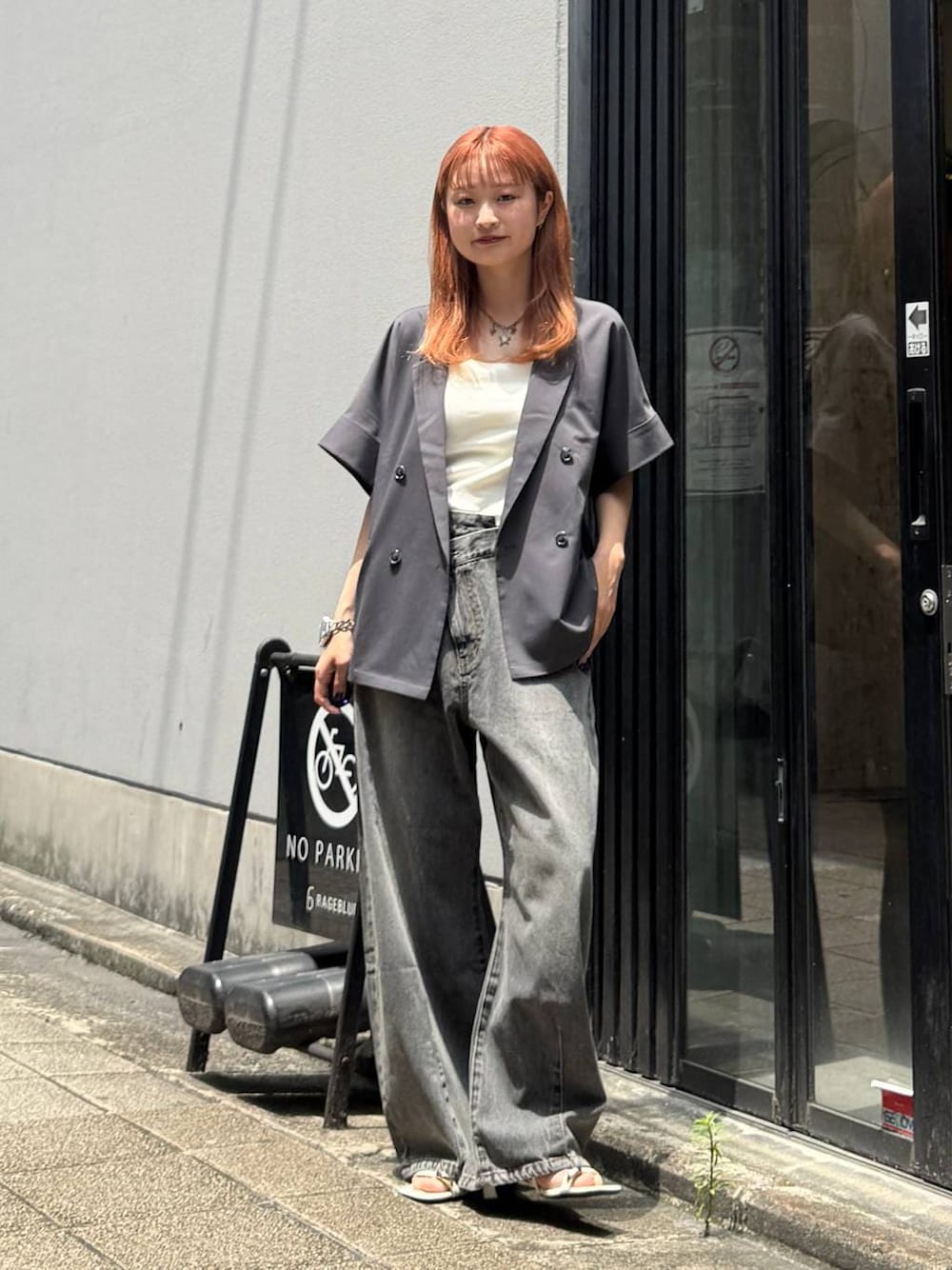 グレー系のデニムパンツ、グレー系のテーラードジャケット、ホワイト系のキャミソールを着用したレディースの夏コーディネートの1枚目の写真