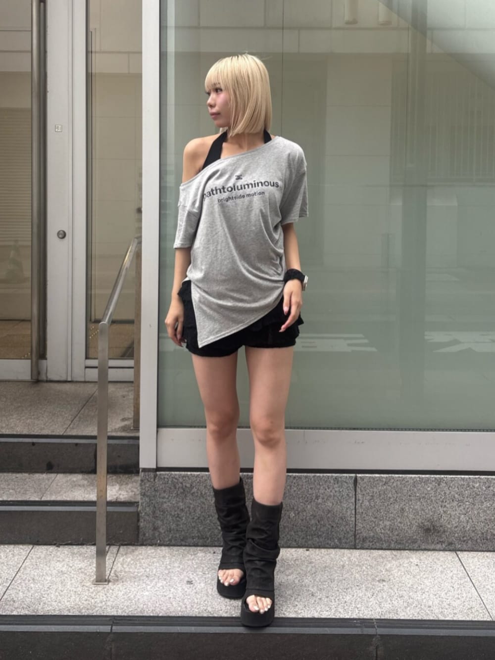 ブラック系のスカート、ブラック系のサンダル、グレー系のTシャツ/カットソーを着用したレディースの夏コーディネートの1枚目の写真