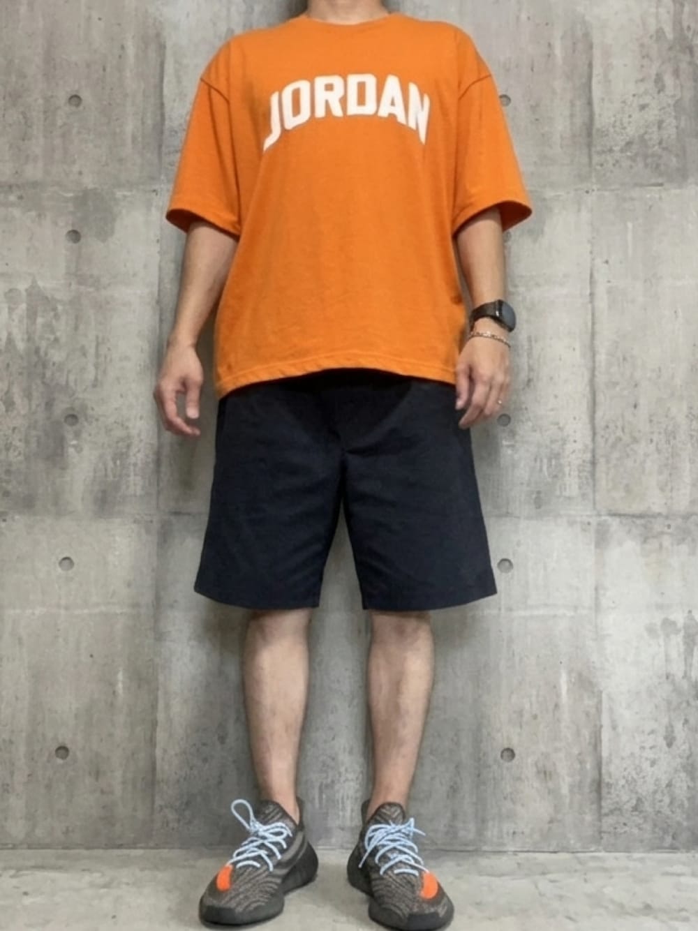 グレー系のスニーカー、ブラック系のその他パンツ、オレンジ系のTシャツ/カットソーを着用したメンズの夏コーディネートの1枚目の写真