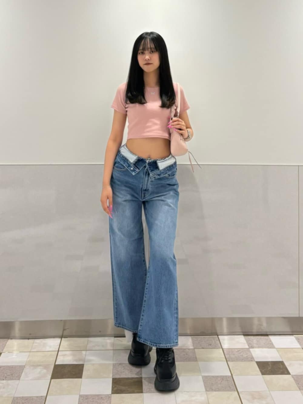 ピンク系のショルダーバッグ、ブルー系のデニムパンツ、ブラック系のスニーカーを着用したレディースの夏コーディネートの1枚目の写真