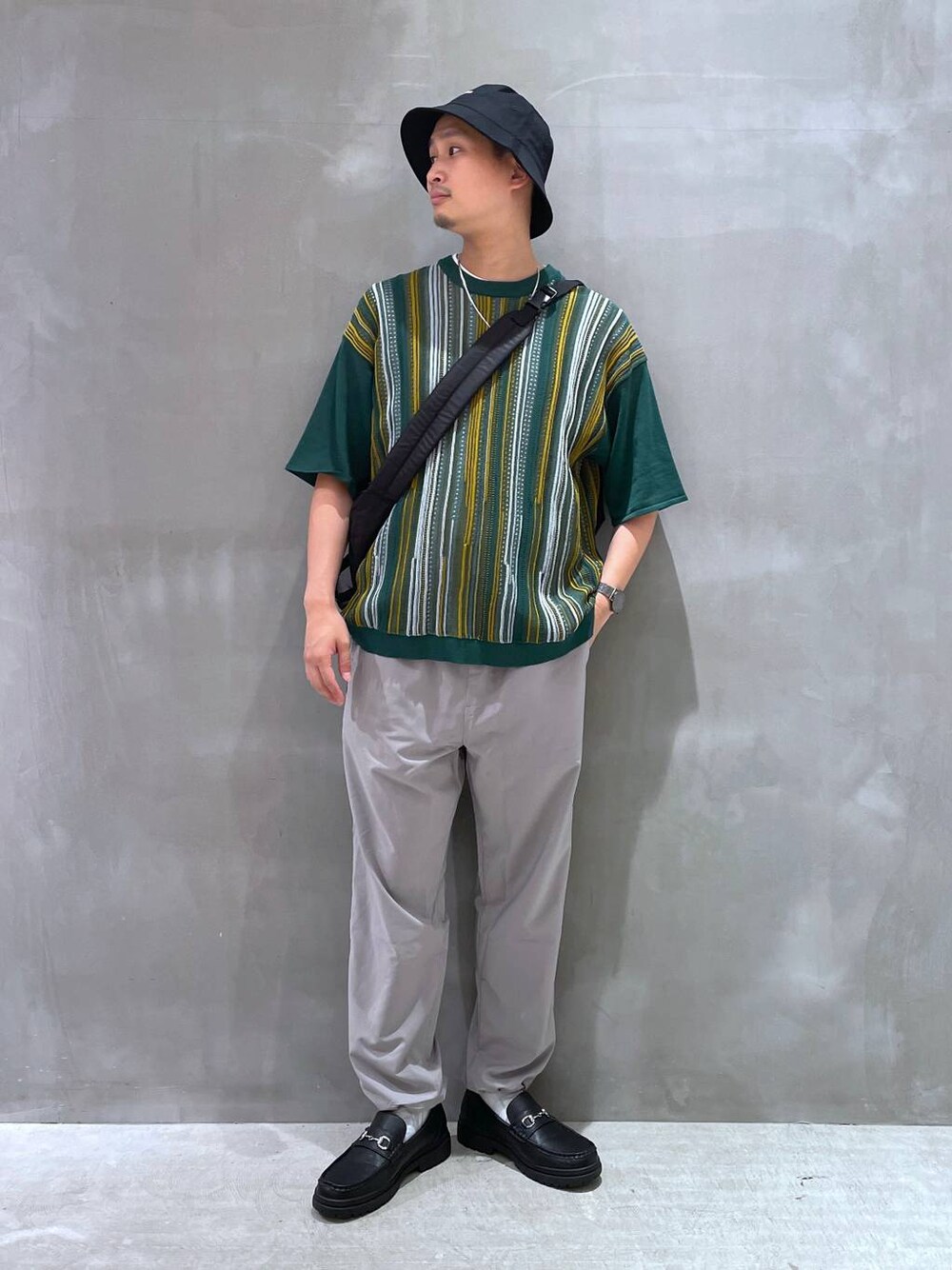 グレー系のTシャツ/カットソー、ブラック系のローファー、ブラック系のショルダーバッグを着用したメンズの夏コーディネートの1枚目の写真