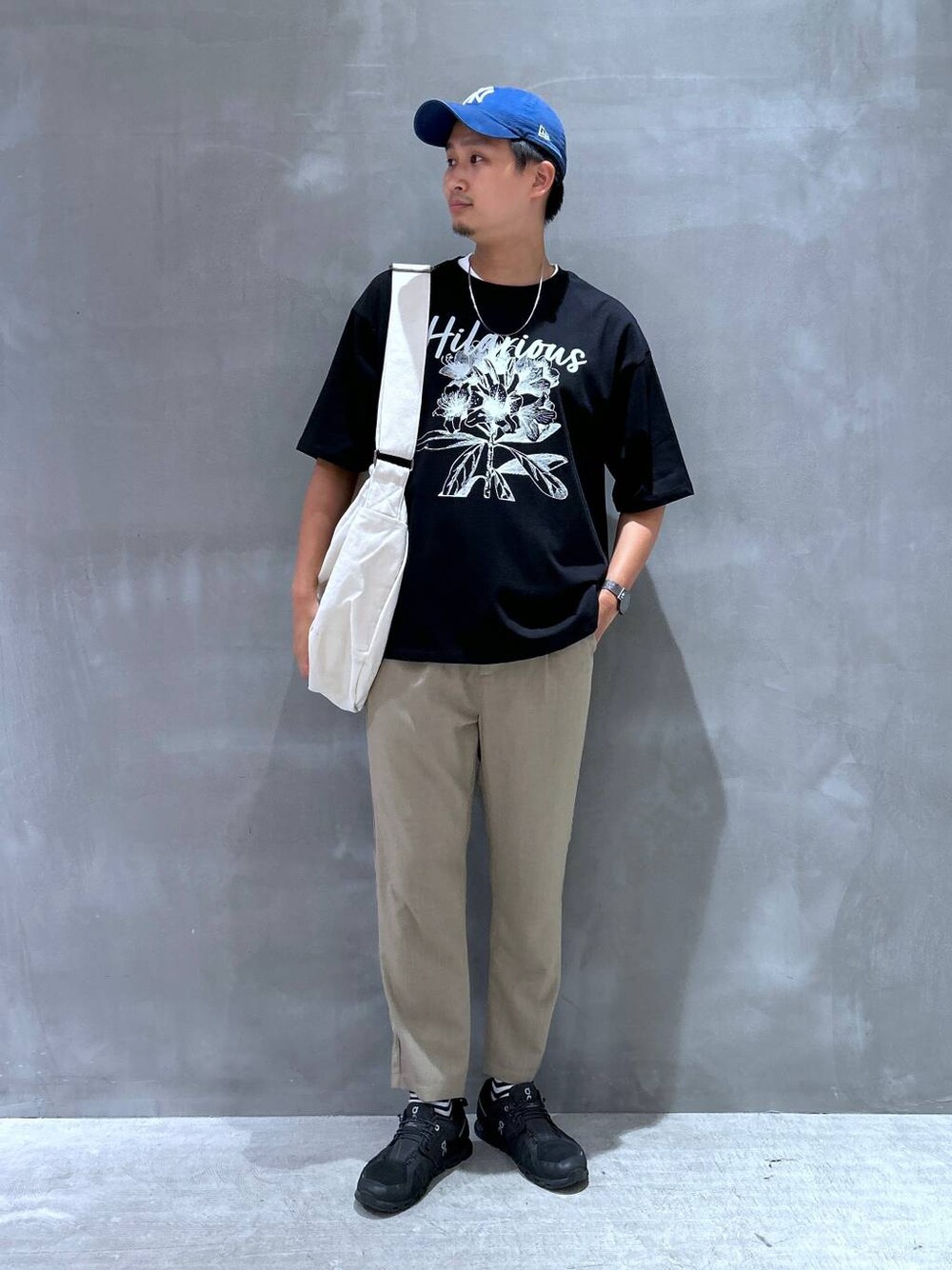 ベージュ系のショルダーバッグ、ベージュ系のその他パンツ、ブラック系のTシャツ/カットソーを着用したメンズの夏コーディネートの1枚目の写真