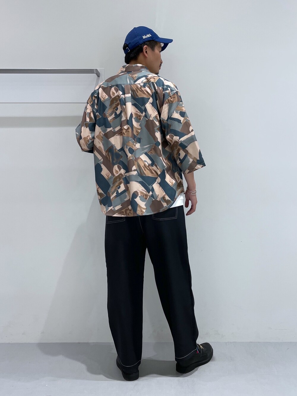 ブラック系のその他パンツ、ブラック系のローファー、グリーン系のシャツ/ブラウスを着用したメンズの春コーディネートの4枚目の写真